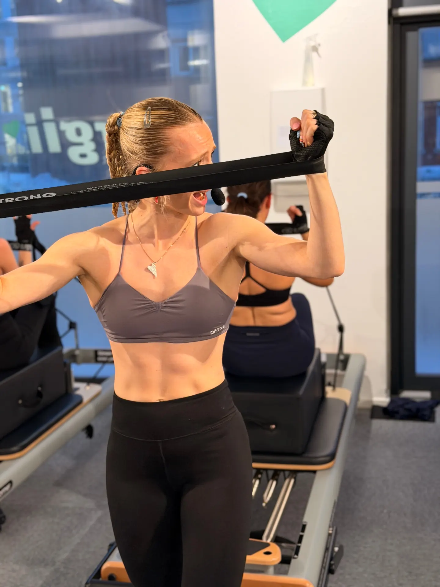 Instructor adjusting a member's form during a reformer class